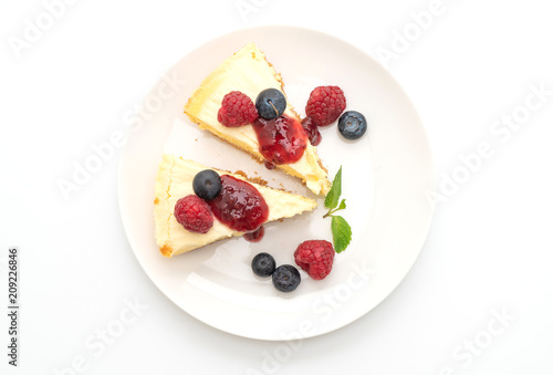 Homemade cheesecake with raspberries and blueberries on white background