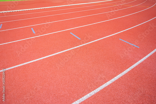 White lines of stadium and texture of running racetrack red rubber racetracks in outdoor stadium are 8 track and green grass field empty athletics stadium with track.