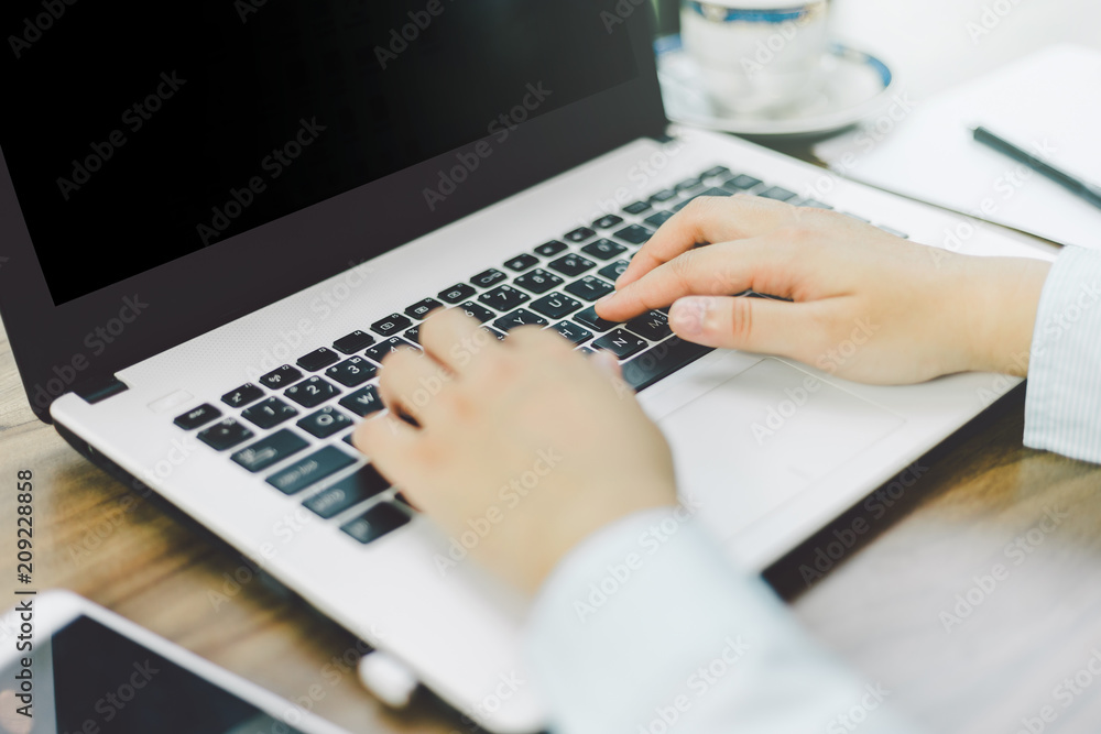Fototapeta premium Close-up of Business female working with laptop coffee in coffee shop like the background.
