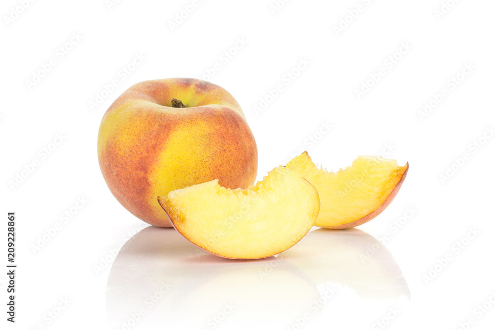 One yellow peach and two sliced pieces isolated on white background.