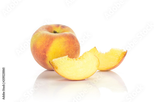 One yellow peach and two sliced pieces isolated on white background.