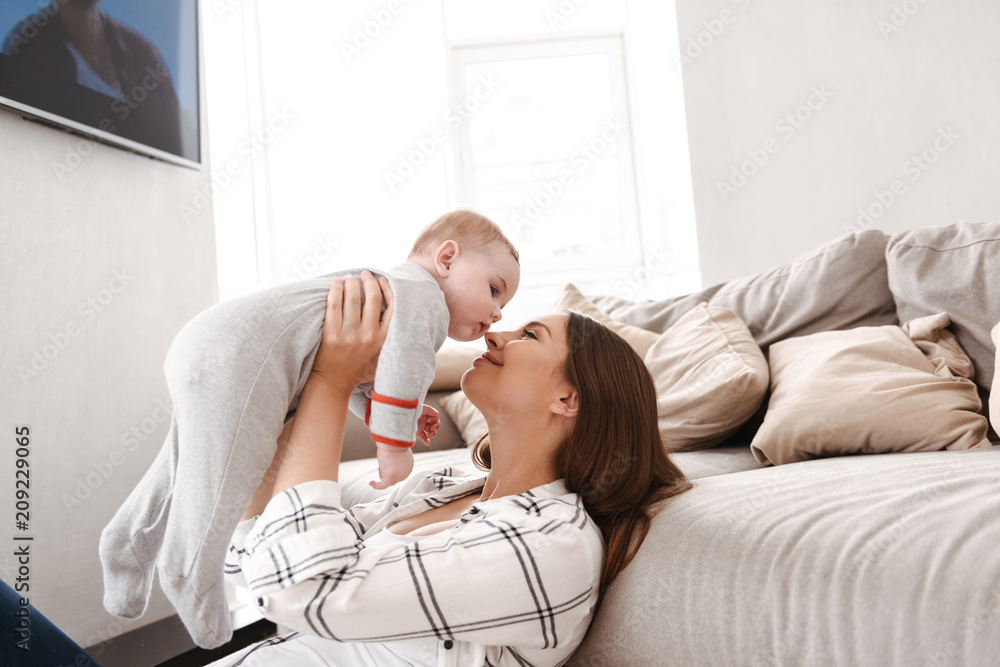 Mother having fun with her little child indoors at home. Mother having fun with her little child indoors at home.