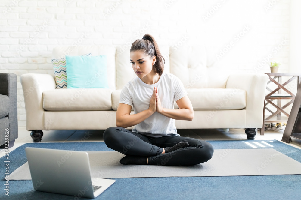 Woman repeating exercises while watching online workout session Woman repeating exercises while watching online workout session
