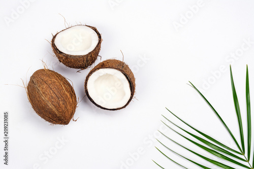 Coconut halves and leaves on white background photo
