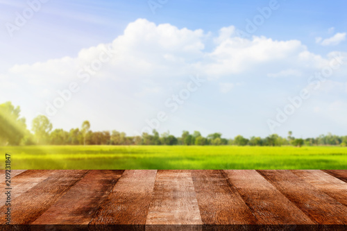 Wooden old table on rice field and cloud background. For your product placement or montage with focus to the table top in the foreground. Empty wooden brown shelf. shelves