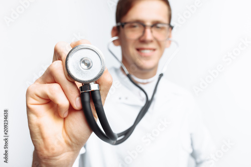 Hand close-up holding stethoscope, Portrait of young doctor on white background