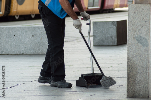 фотографія closeup of man cleaning the front of train station with broom