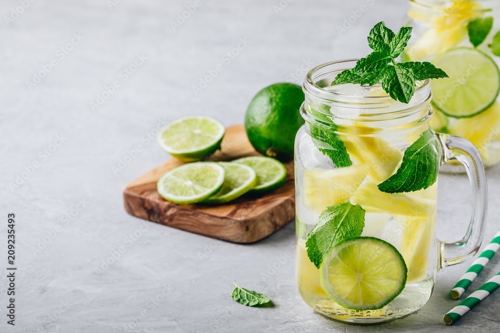 Fototapeta premium Infused detox water with pineapple, lime and mint. Ice cold summer cocktail or lemonade