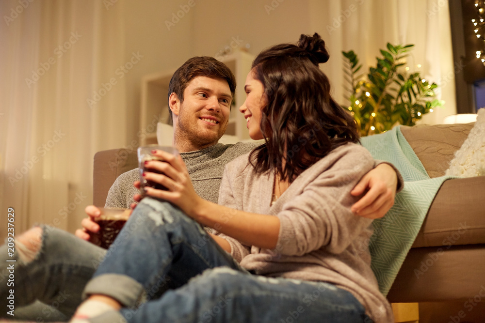 hygge, leisure and people concept - happy couple drinking coffee and eating at home hygge, leisure and people concept - happy couple drinking coffee and eating at home