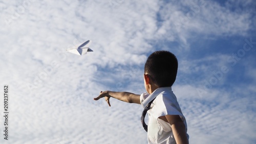 Asian school boy playing with paper airplane.(Selected focus)