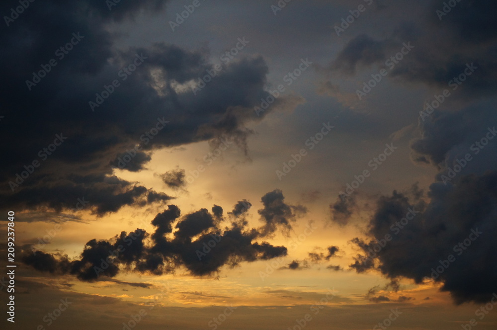 Dark clouds at sunset sky