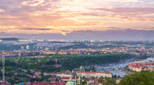 Beautiful high view of Prague and the Vltava river on a cloudy pink sky at sunset. European cityscape at twilight