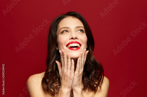 beauty, make up and people concept - happy smiling young woman with red lipstick posing over white background