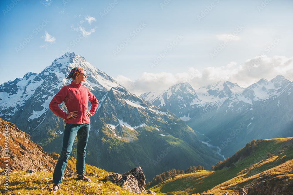 Woman hiker standing on the top of mountain