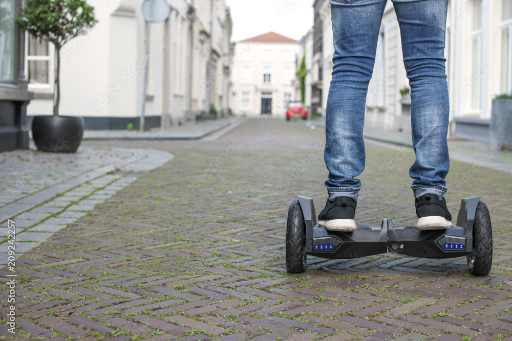 Modern technology, a man is riding on a blackboard. Close Up of Dual Wheel Self Balancing Electric Skateboard Smart. on electrical scooter outdoors. Copy space. Modern technology, a man is riding on a blackboard. Close Up of Dual Wheel Self Balancing Electric Skateboard Smart. on electrical scooter outdoors. Copy space.