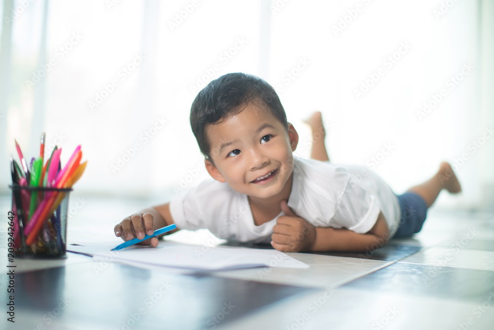 happy Asia little boy writing something in paper,flare light happy Asia little boy writing something in paper,flare light