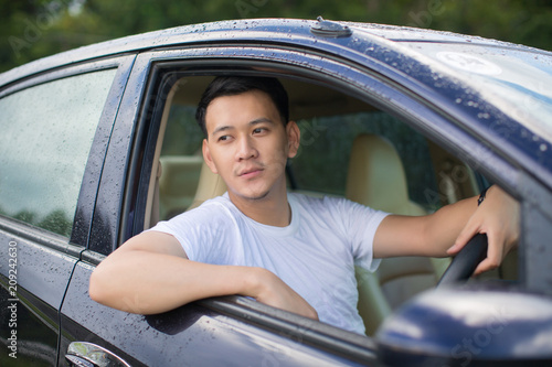 Close up of a handsome Asia man siting in his car.Travel concept..