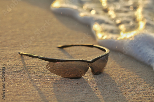 lentes de sol sobre la arena en la playa photo