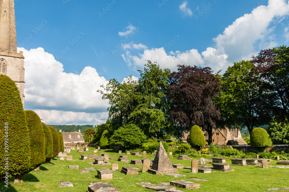 An ancient church and graveyard in the scenic Cotswolds area of England on a summers day (Painswick)