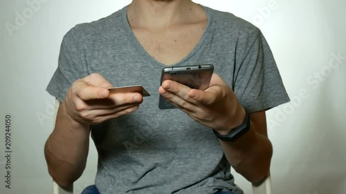guy is spending money with a credit card and smartphone