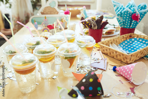 Girl birthday decorations. table setting from above with cakes, drinks and party gadgets.