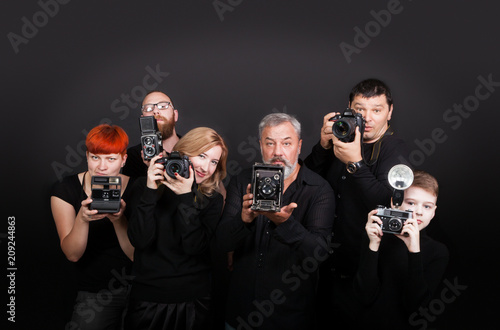 A group of people of different ages, children, women and men holding cameras. The concept of a hobby and study in a photo school