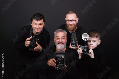 A group of men of different ages, a boy and men holding cameras. The concept of a hobby and study in a photo school
