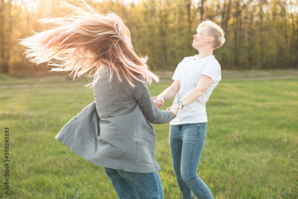 Fototapeta premium Two women dancing on the green field