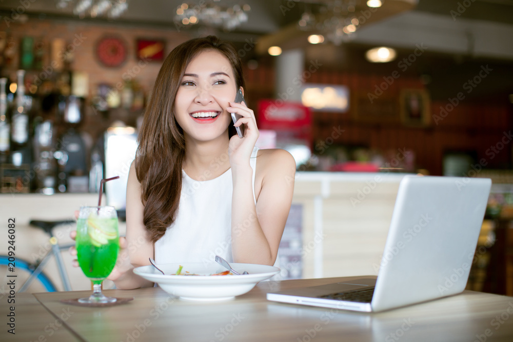 Young woman eating Spaghetti at restaurant and talking on smart phone Young woman eating Spaghetti at restaurant and talking on smart phone