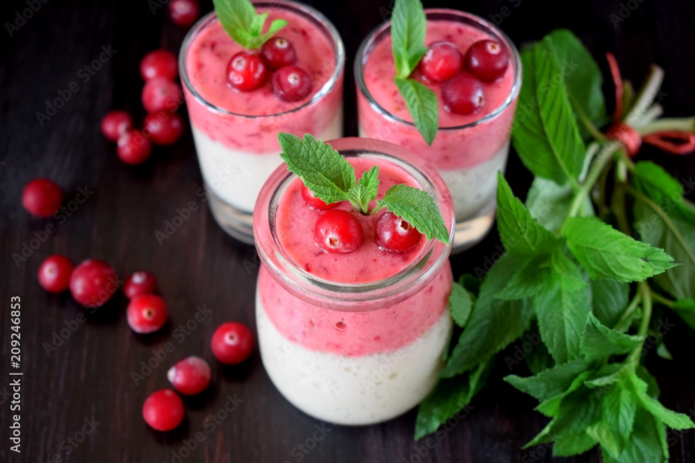 Two layered smoothie with cranberry and banana in a glass jar against the dark background Two layered smoothie with cranberry and banana in a glass jar against the dark background