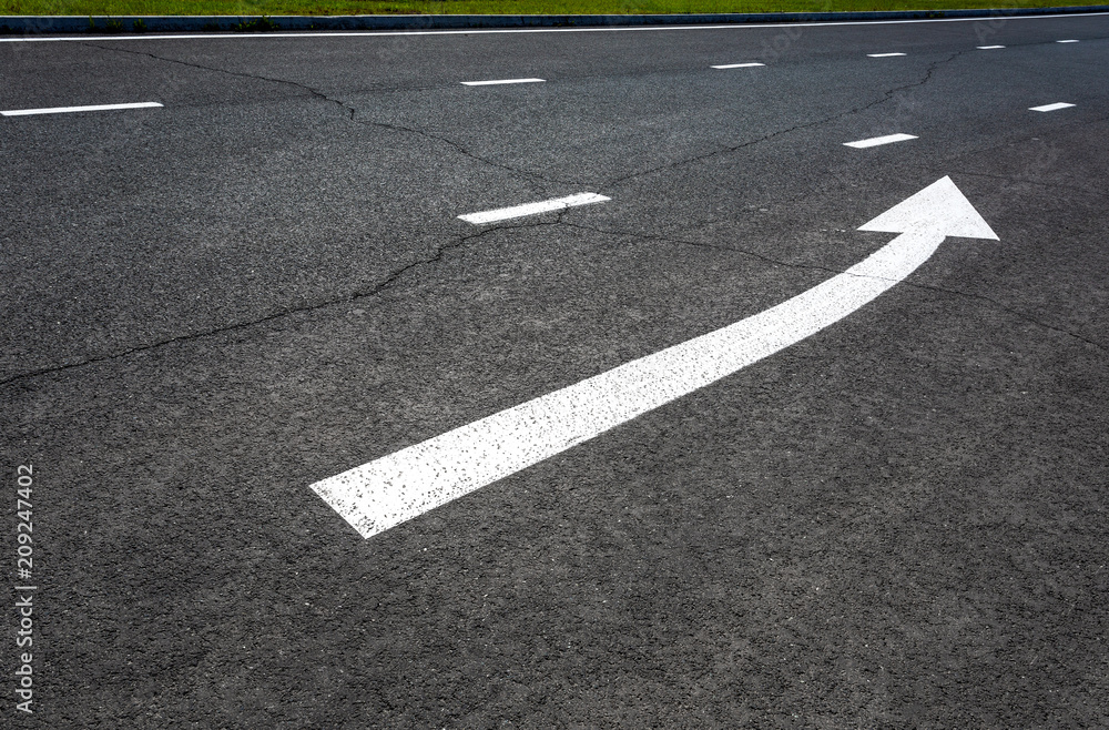 Traffic sign white arrow on asphalt road