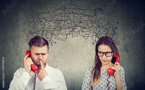 Photography confused couple woman and man talking on the phone exchanging with many negative