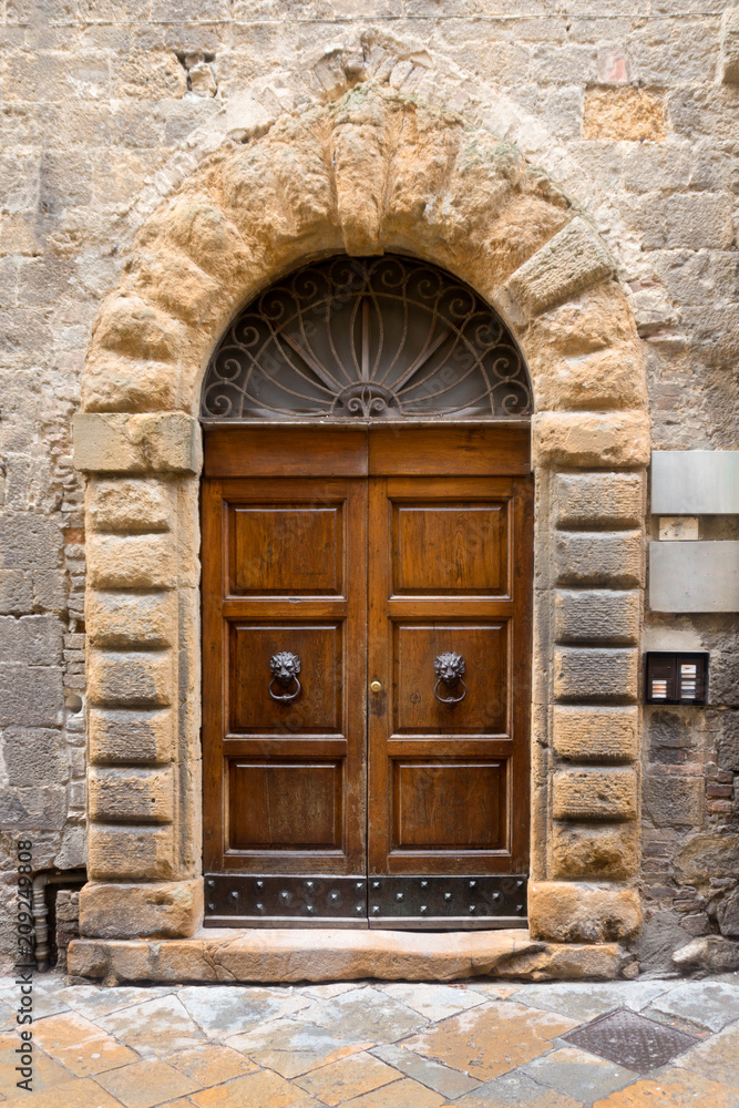 A grand front door in the medieval town of Volterra, Italy.