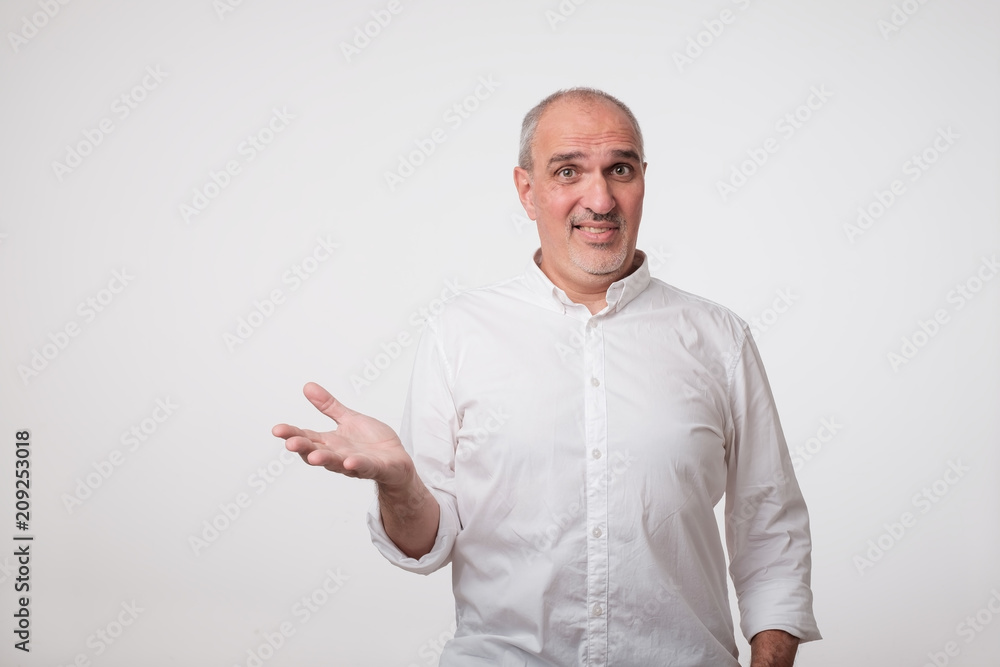 What do you mean concept. Puzzled mature man in white shirt