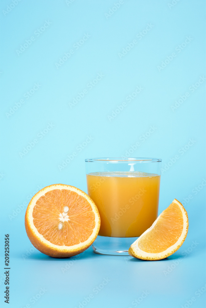 Fresh juice and orange on a blue background with place for a text. Fresh juice and orange on a blue background with place for a text.