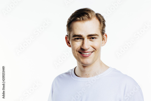 Portrait of a young smiling man in a white shirt , isolated on white studio background