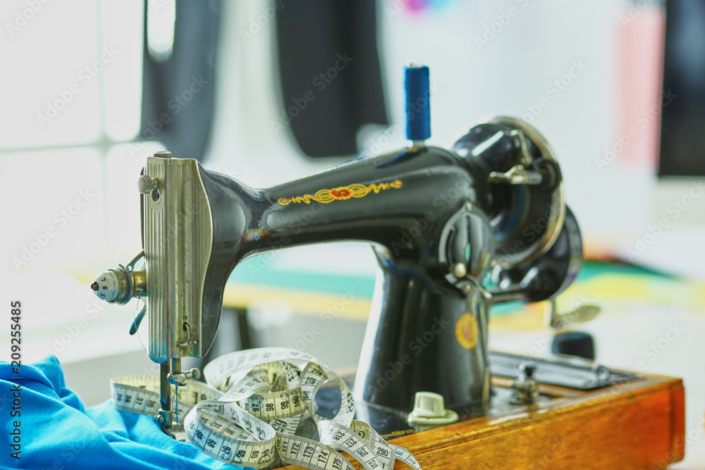 Fototapeta premium Retro sewing machine on designer clothes desktop