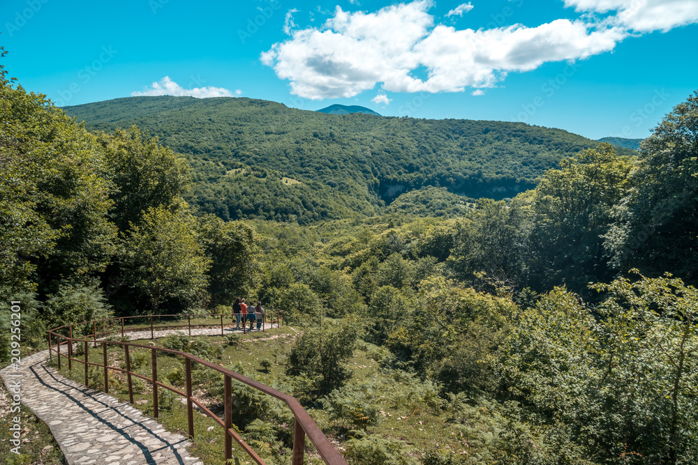 Zeda-gordi, Georgia. View Of Paved Forest Path and wooden bridge Leading To Canyon Okatse