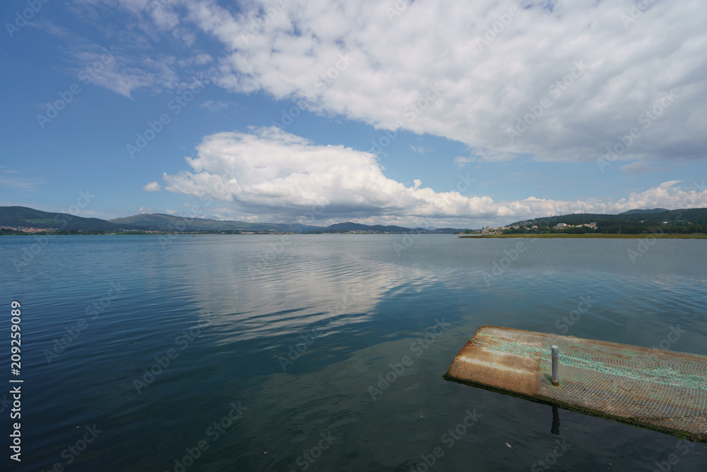 The estuary of the River Minya (northern Portugal). It flows into the Atlantic Ocean here. The place where the sky converges with the earth, clouds reflect in water