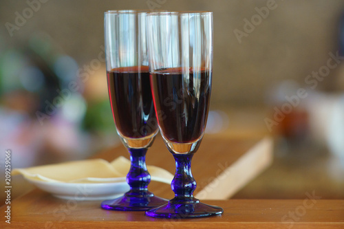 Evening at home, two glasses of red wine and cheese are waiting for someone. Abstract home light bokeh defocused background