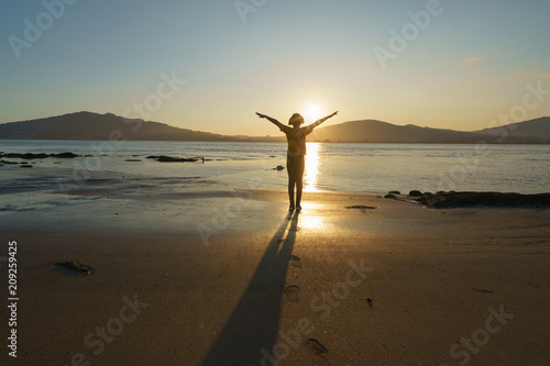 The river Minaya (Minha) image (northern Portugal). The girl raised her hands in the setting sun photo