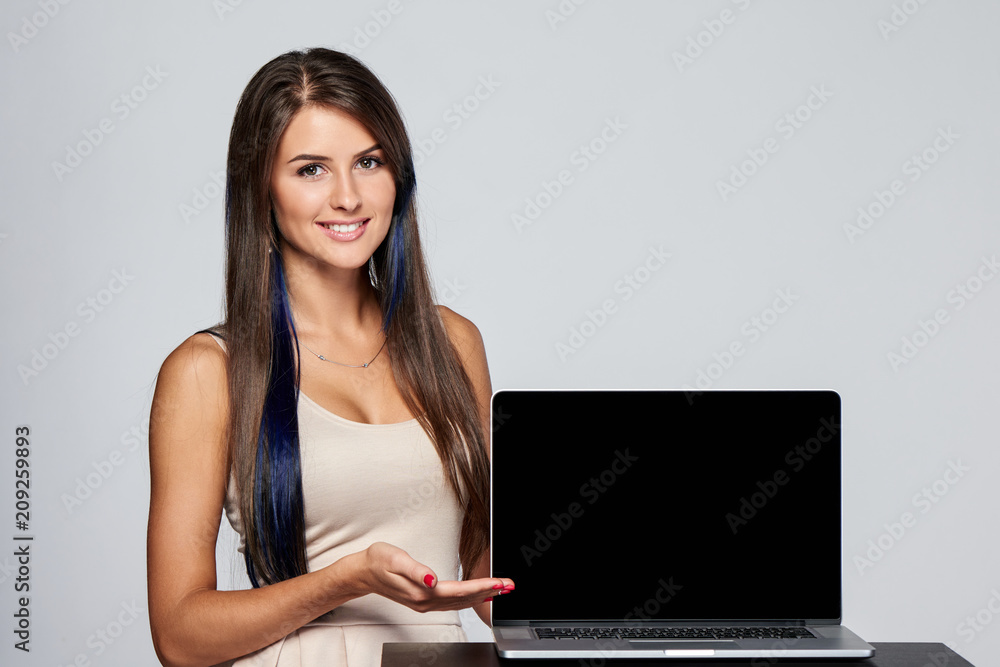 Happy woman showing presenting blank copy space at black laptop computer screen, looking at camera smiling Happy woman showing presenting blank copy space at black laptop computer screen, looking at camera smiling
