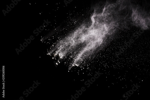  Freeze motion of white dust explosion on black background. Stopping the movement of white powder on dark background. Explosive powder white on black background.