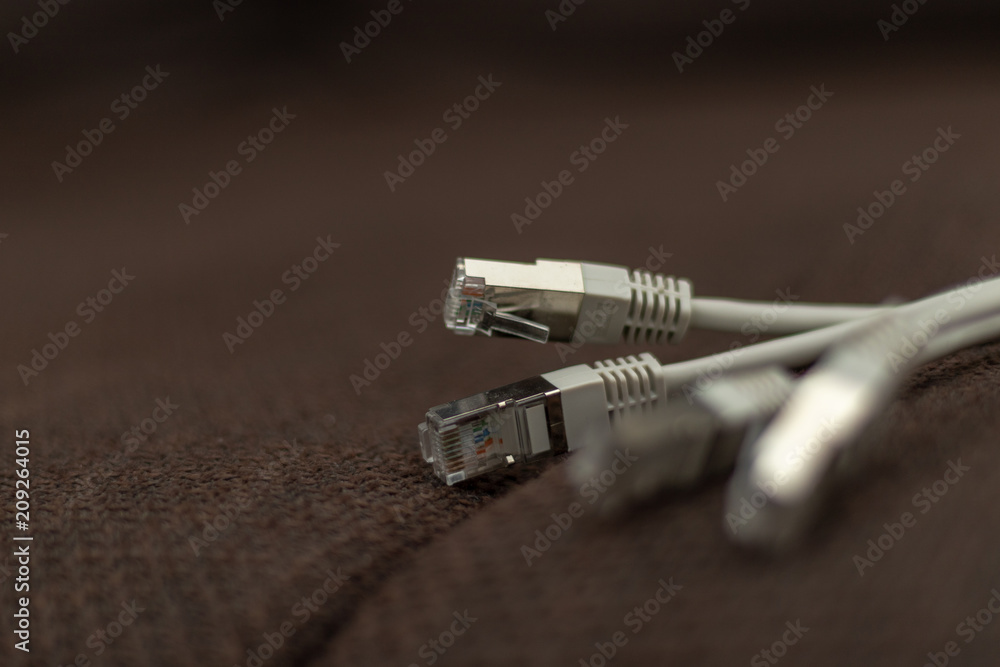 Bunch of network cables lying on a brown fabric furface Bunch of network cables lying on a brown fabric furface