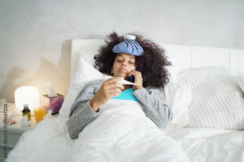 © Diego Cervo - Woman With Fever Using Thermometer And Calling Doctor By Phone