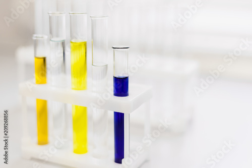 Glass tubes with color reagents stand in a laboratory tripod. Soft focus. Medical and scientific research and development concept. Copy space.