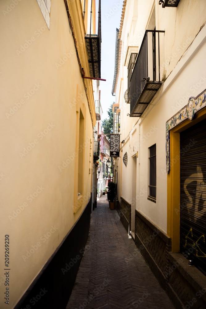 Spain, Seville, NARROW ALLEY AMIDST BUILDINGS IN CITY Spain, Seville, NARROW ALLEY AMIDST BUILDINGS IN CITY