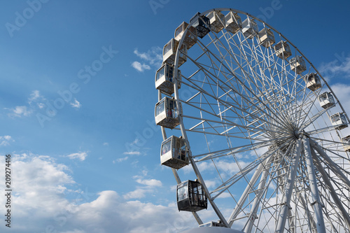 A wheel of review is in the park of entertainments, on a background blue sky