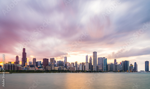 chicago,illinois,usa. 8-11-17: Chicago skyline at sunset with cloudy sky and reflection in water. © checubus