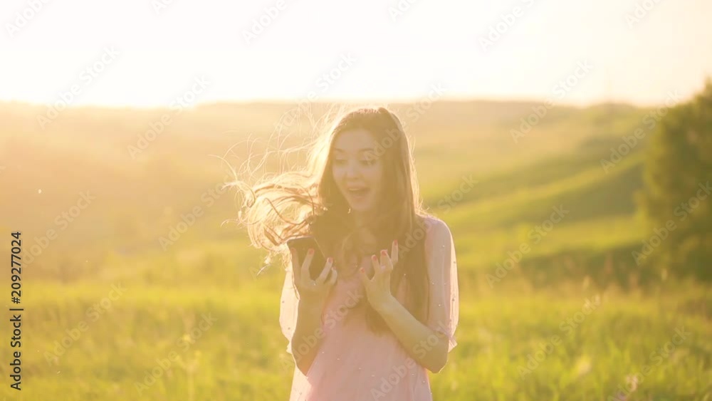 The girl won the mobile game. Very pleased. Beautiful girl uses a mobile phone outdoors. Holds his smartphone. The girl is happy and jumping from winning The girl won the mobile game. Very pleased. Beautiful girl uses a mobile phone outdoors. Holds his smartphone. The girl is happy and jumping from winning
